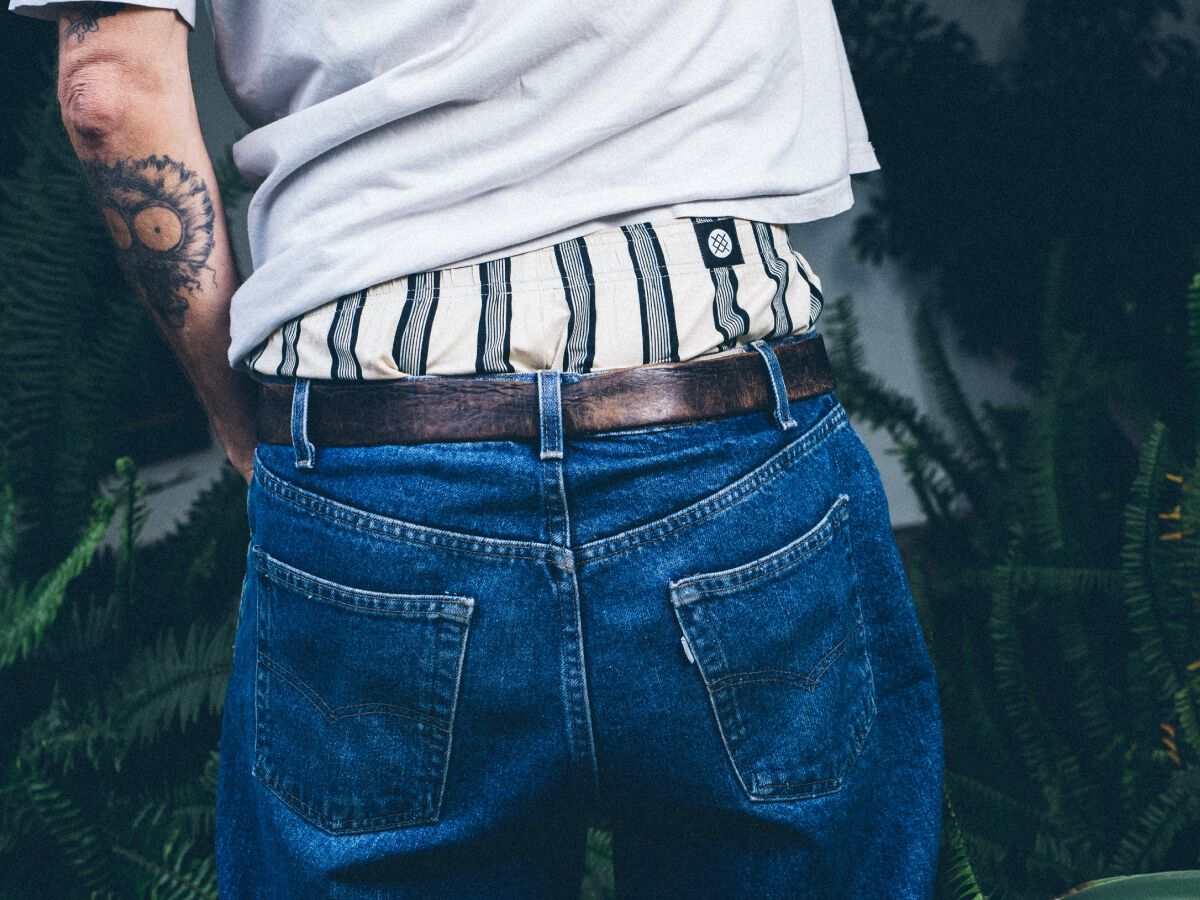 photo of a man wearing ivory and navy stripe boxers under a pair of jeans.