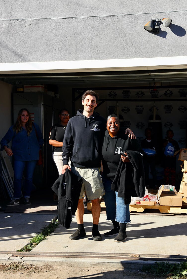 Two people smiling outside a garage