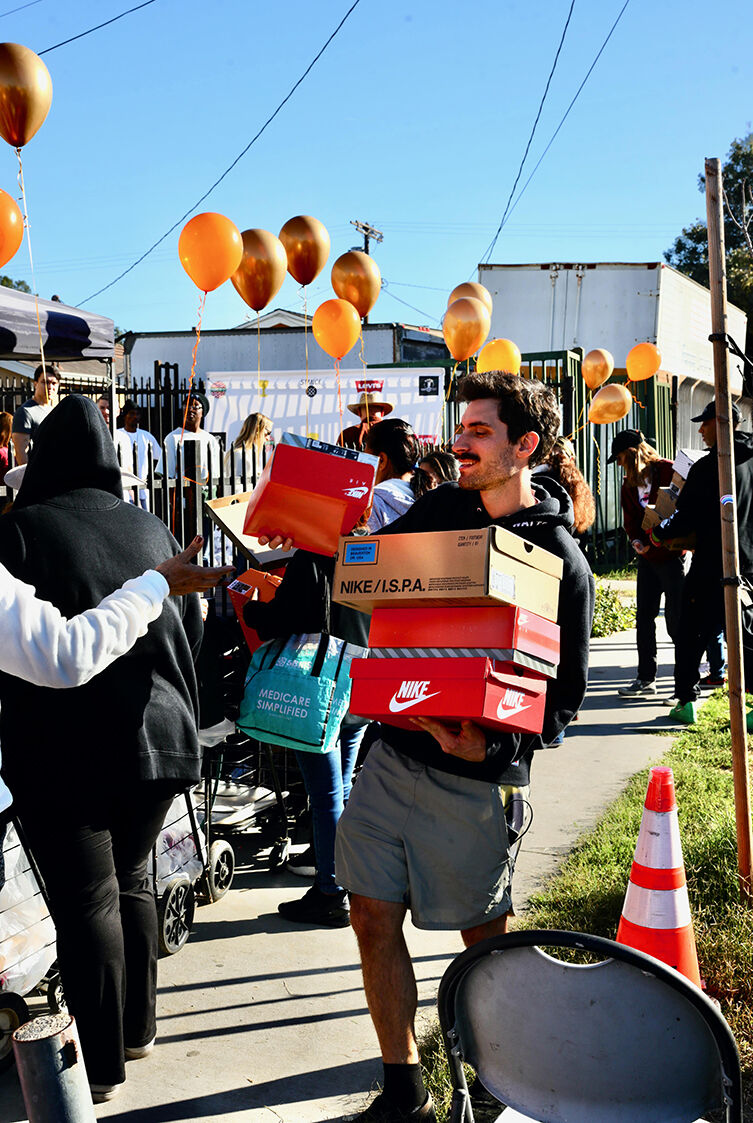 man handing out shoes